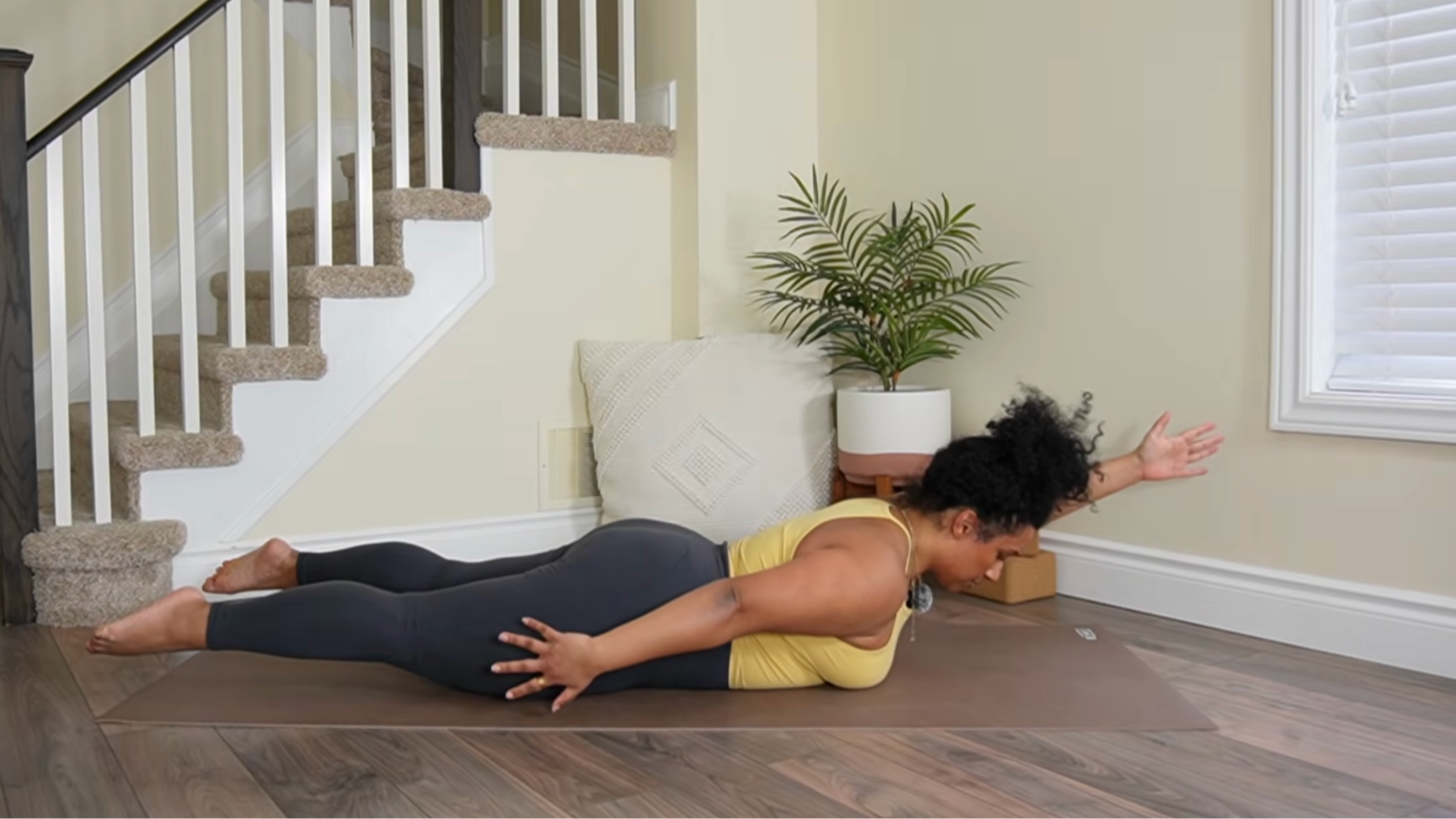 Yoga teacher practicing Locust Pose variation.